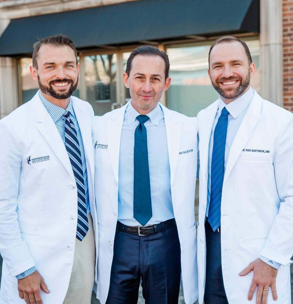 Northshore Oral & Facial Surgery Three NorthShore oral surgeons in white coats standing outside the office