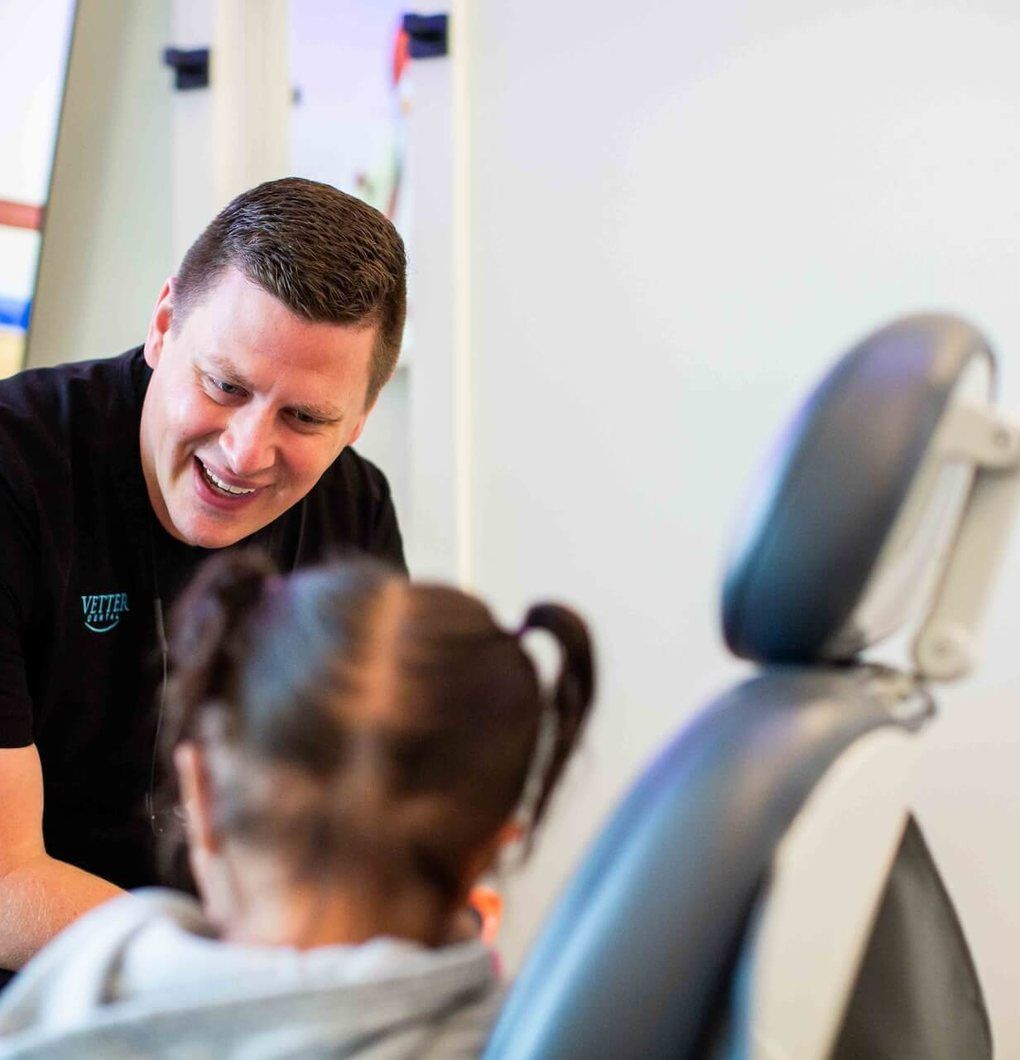 Vetter Dental Dentist laughing with a young patient in the chair at Vetter Dental